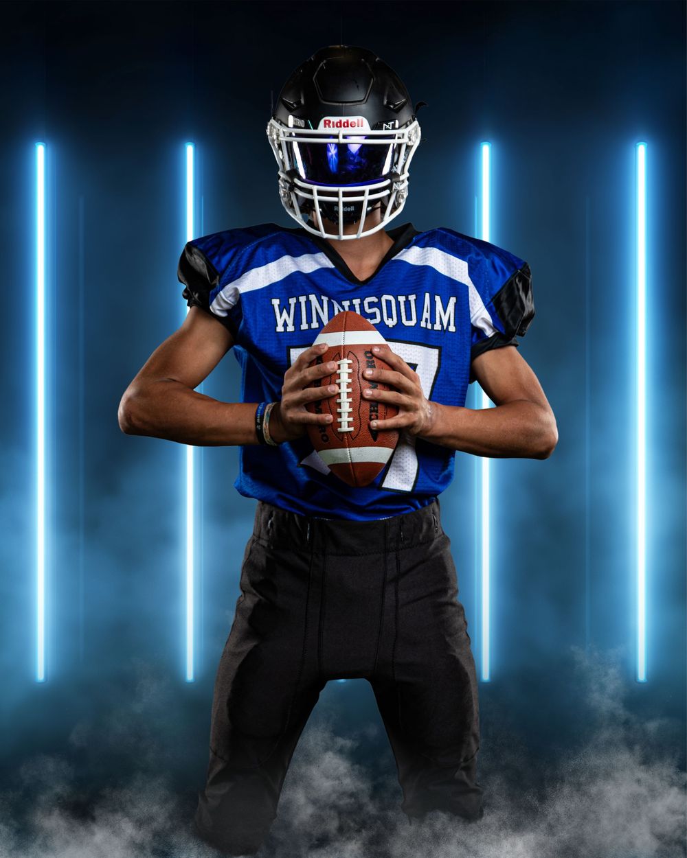 Football players in blue uniforms posing with dramatic blue neon lighting effects.