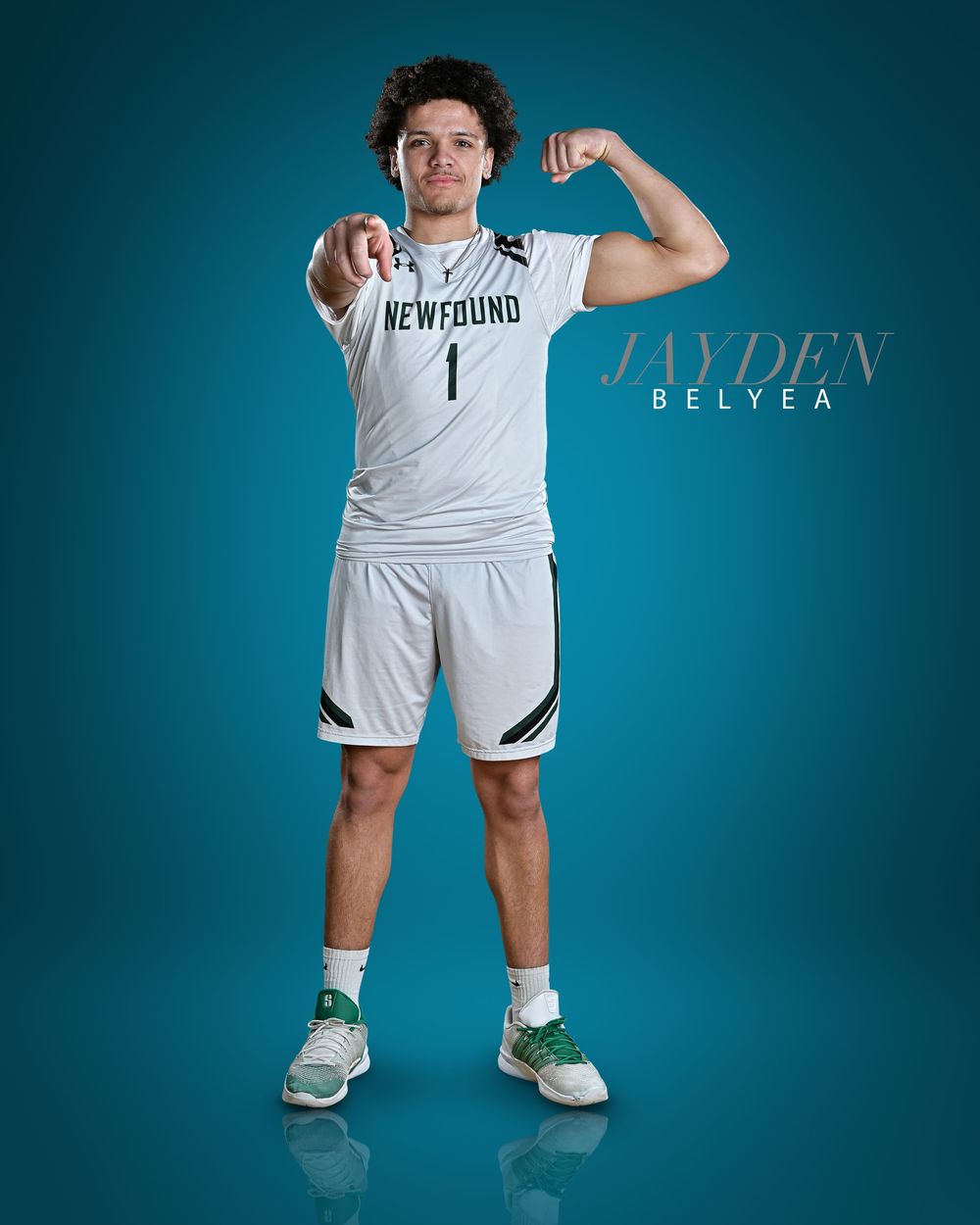 Basketball player in white Newfound jersey number 1 poses against teal background.