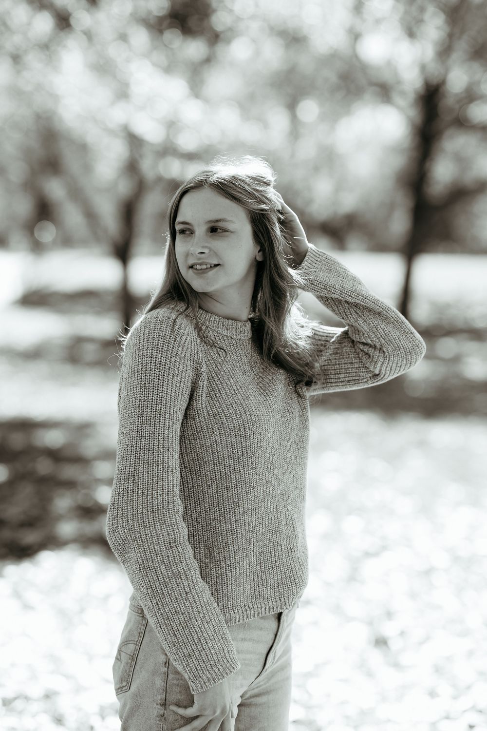 Black and white photos of woman in a knit sweater posing against a fall backdrop in Grand Rapids Michigan.