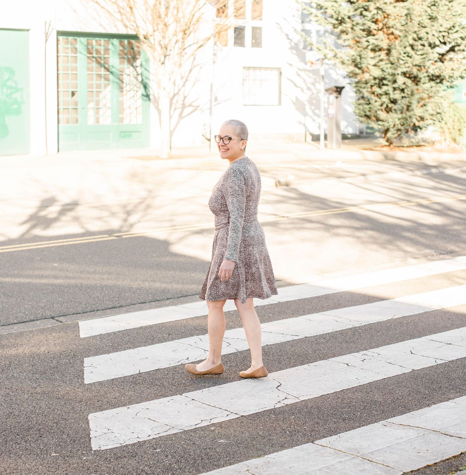 Someone wearing a floral dress walks across a crosswalk in a sequence of progressive steps.