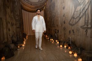 Atmospheric hallway lined with glowing candles and draped fabric creating a romantic ambiance.