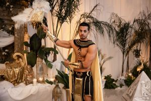 Ancient Egyptian themed costume party with palm trees and theatrical lighting.