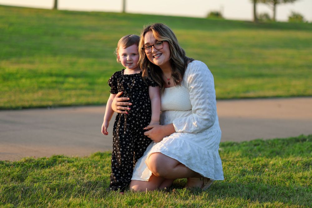 A heartwarming outdoor portrait in a grassy park at golden hour.