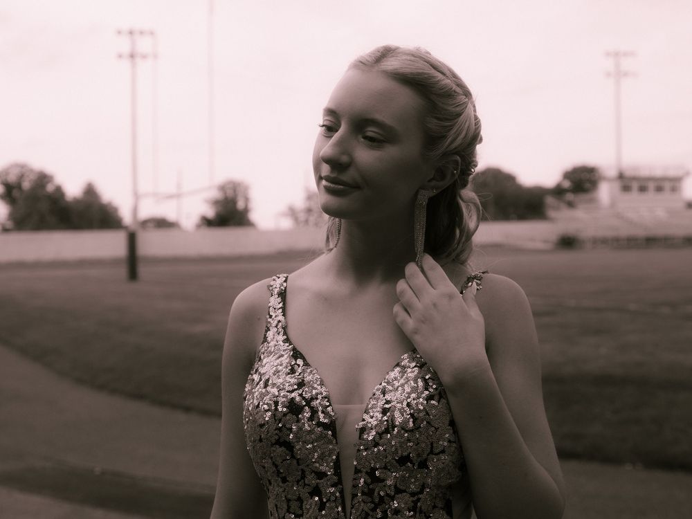 Artistic sepia portrait showcasing an elegant formal gown with delicate beaded details.