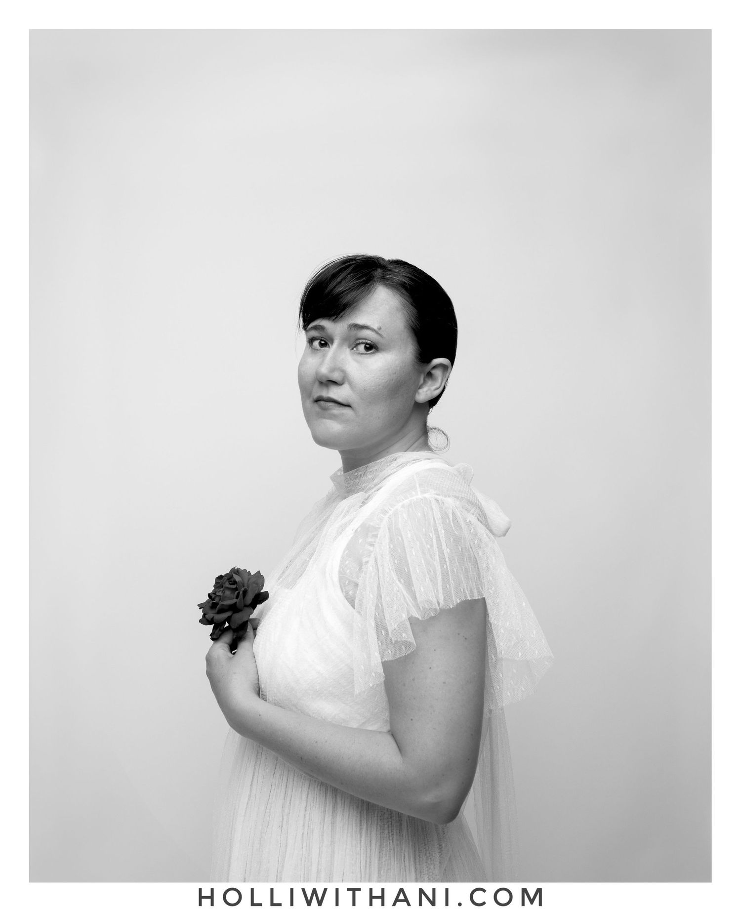 Black and white portrait of woman holding rose