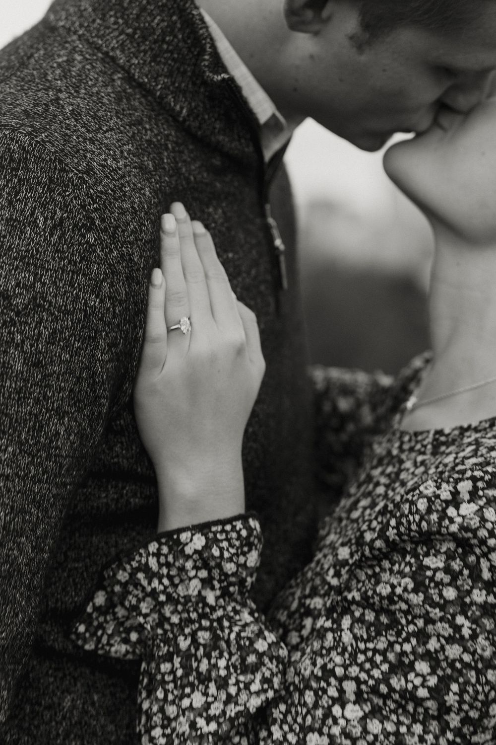 A romantic black and white photo series showing a couple embracing and sharing an intimate kiss.
