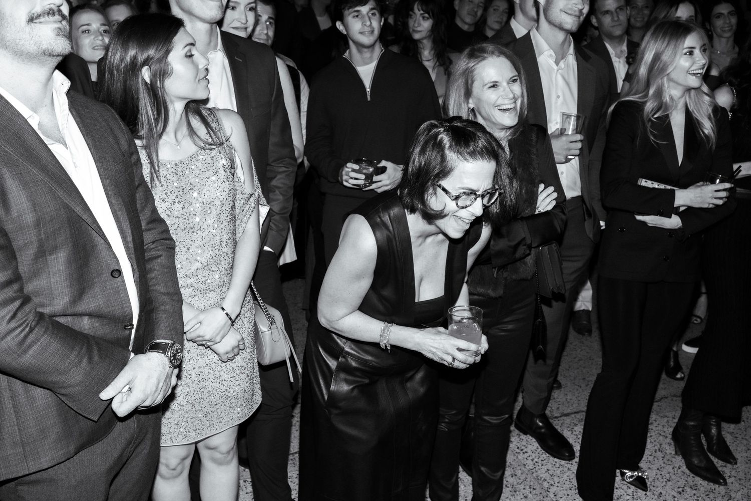 Black and white photo of elegantly dressed party guests mingling at a formal event.