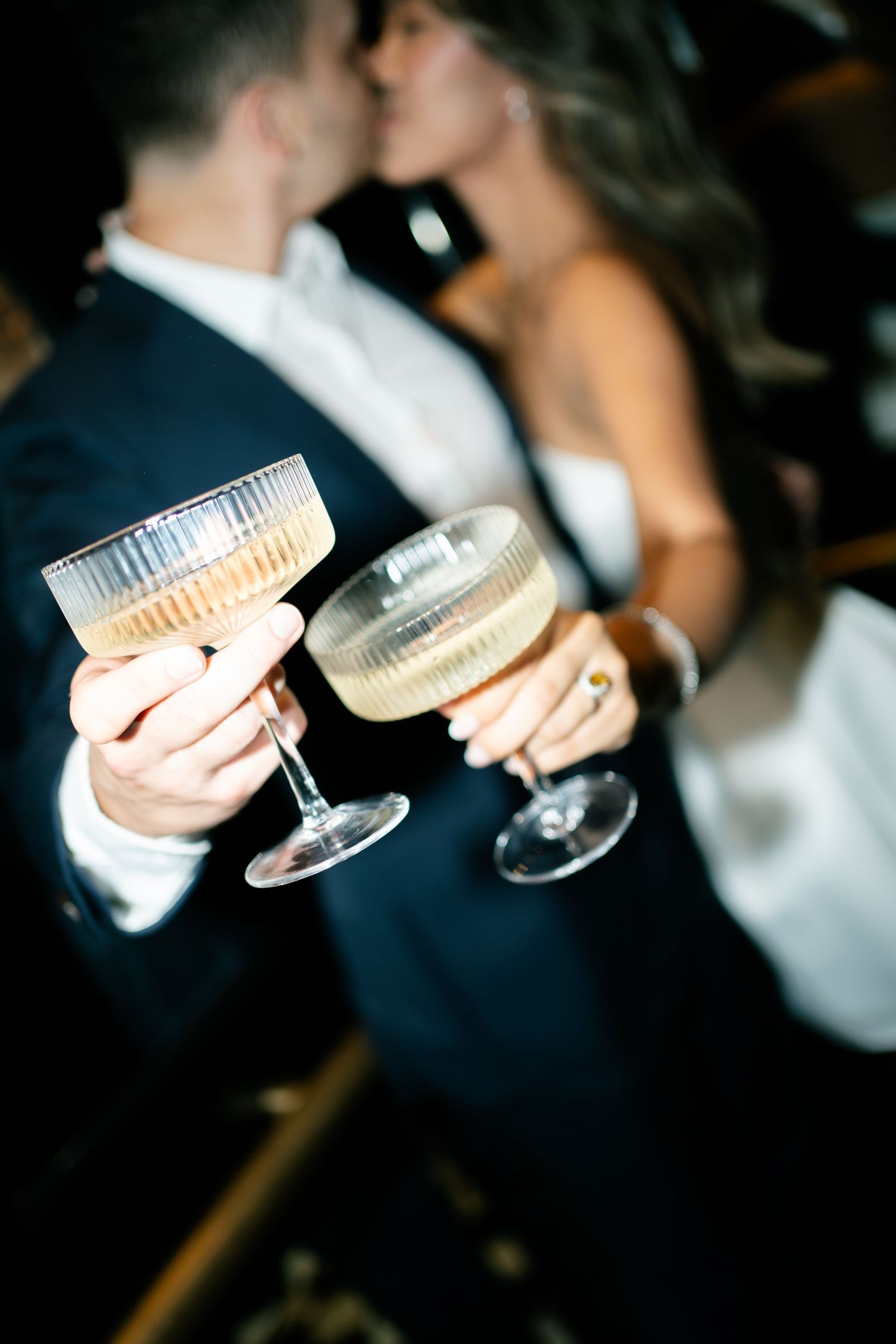 Couple holding champagne glasses in formal attire at evening celebration.