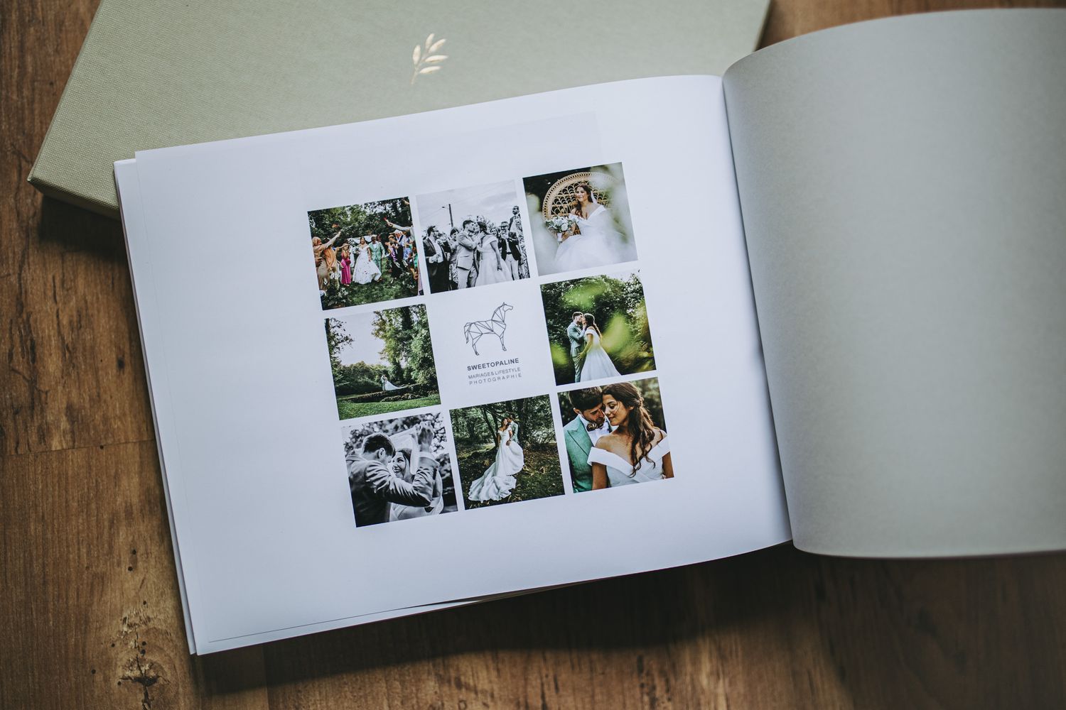 Wedding photo album spread with multiple black and white photographs displayed on white pages against a wooden surface.