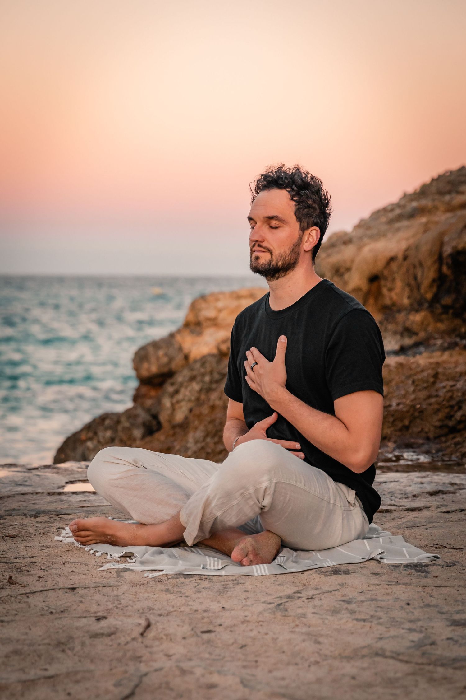 branding photography session of male entrepreneur sitting on rocks in Mallorca.