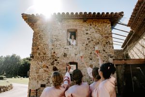 Wedding celebration inside a rustic stone building with exposed beams and natural lighting.