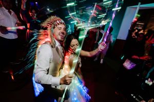 Wedding reception dance party with colorful lighting and energetic atmosphere.