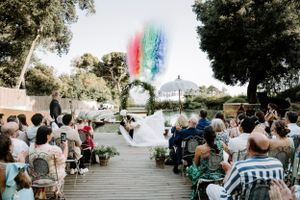 Outdoor wedding ceremony setup with rows of chairs under tree canopy.