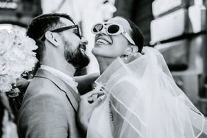 Joyful wedding celebration with dancing and laughter in black and white.