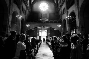Dramatic black and white photo of church interior with chandeliers and natural light streaming in.