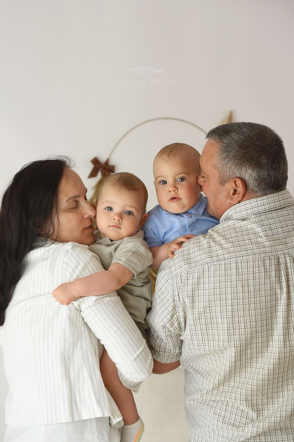 A series of four connected photos showing tender family moments with a baby between two adults against a light background.