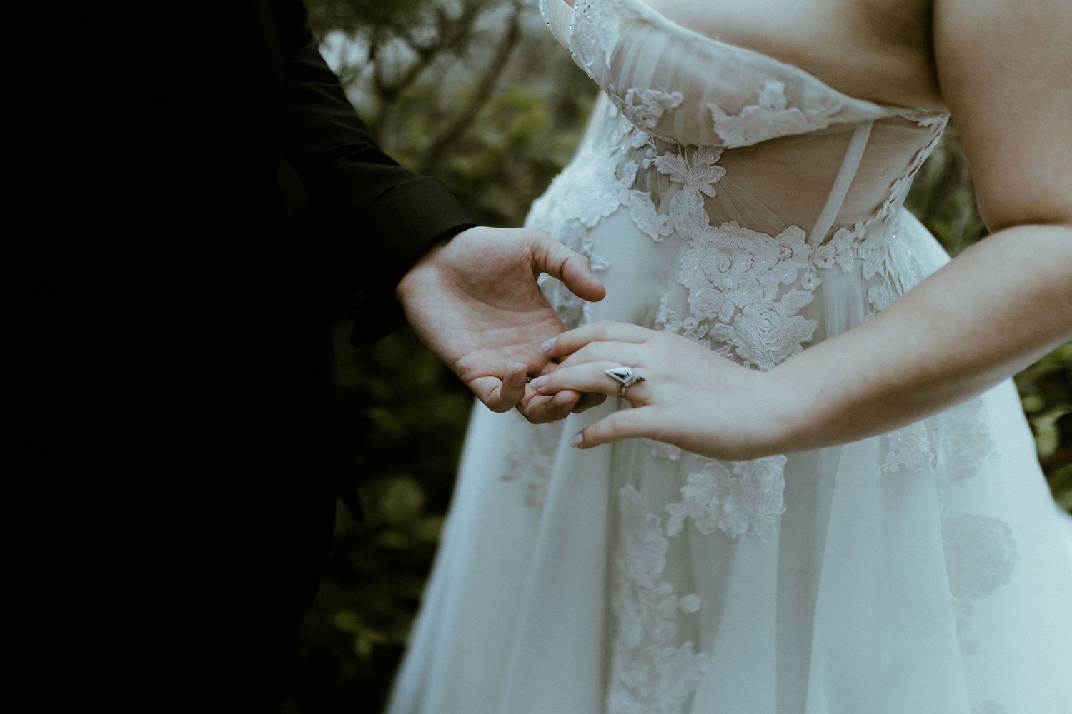 Detail shot of an elegant white lace wedding dress bodice.