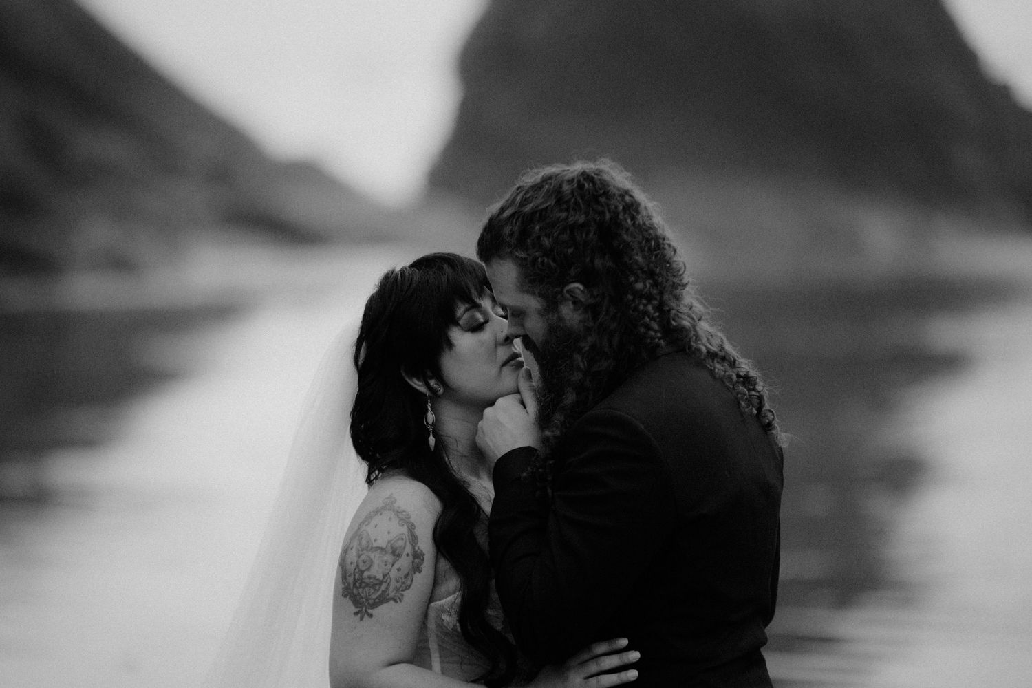 A romantic black and white portrait captures an intimate moment between two people.