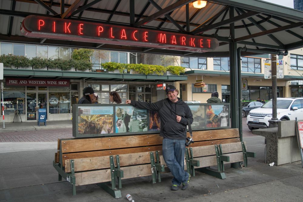 Iconic Pike Place Market entrance sign with bench seating underneath.