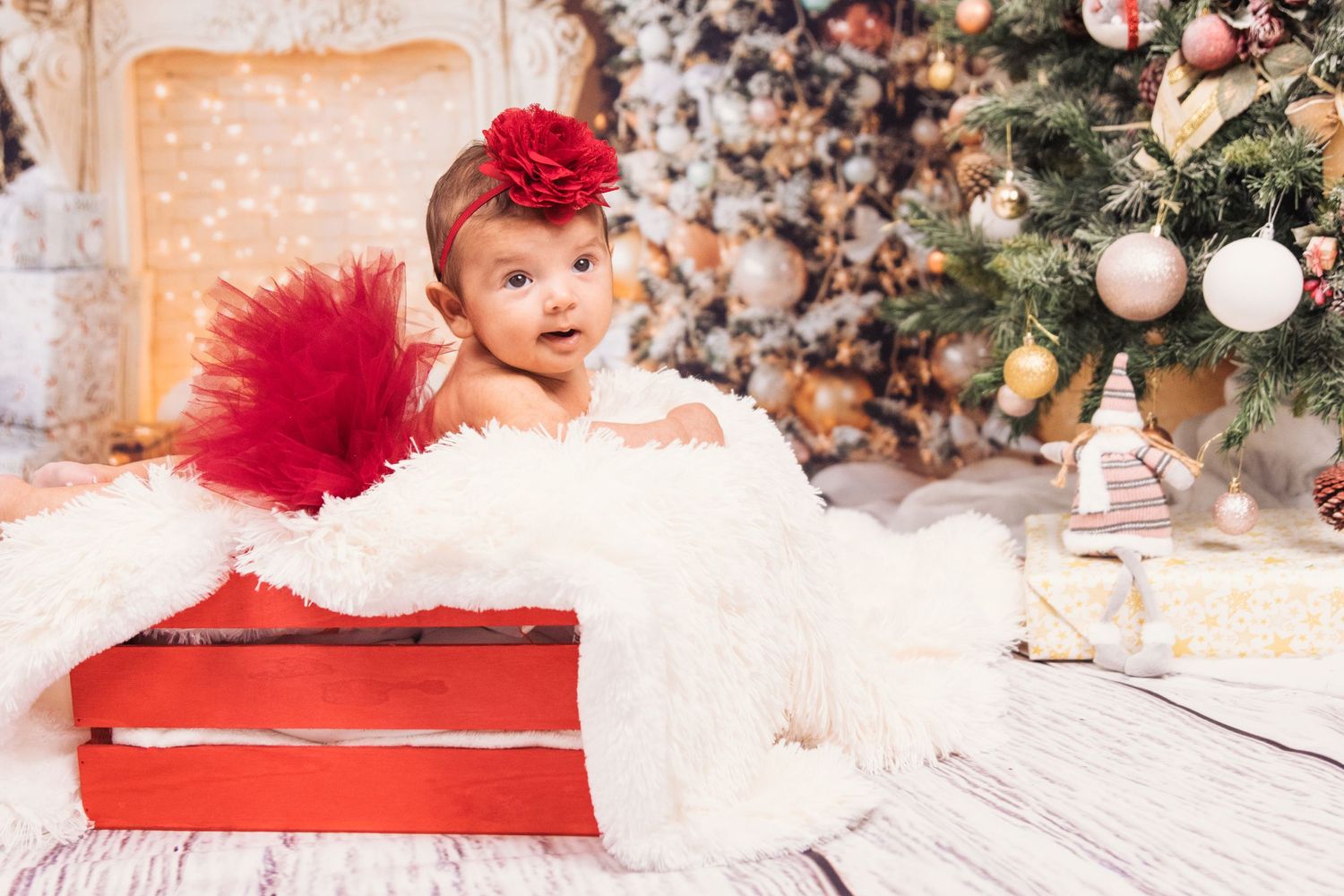 Holiday themed newborn photo session with red accents and Christmas decorations.