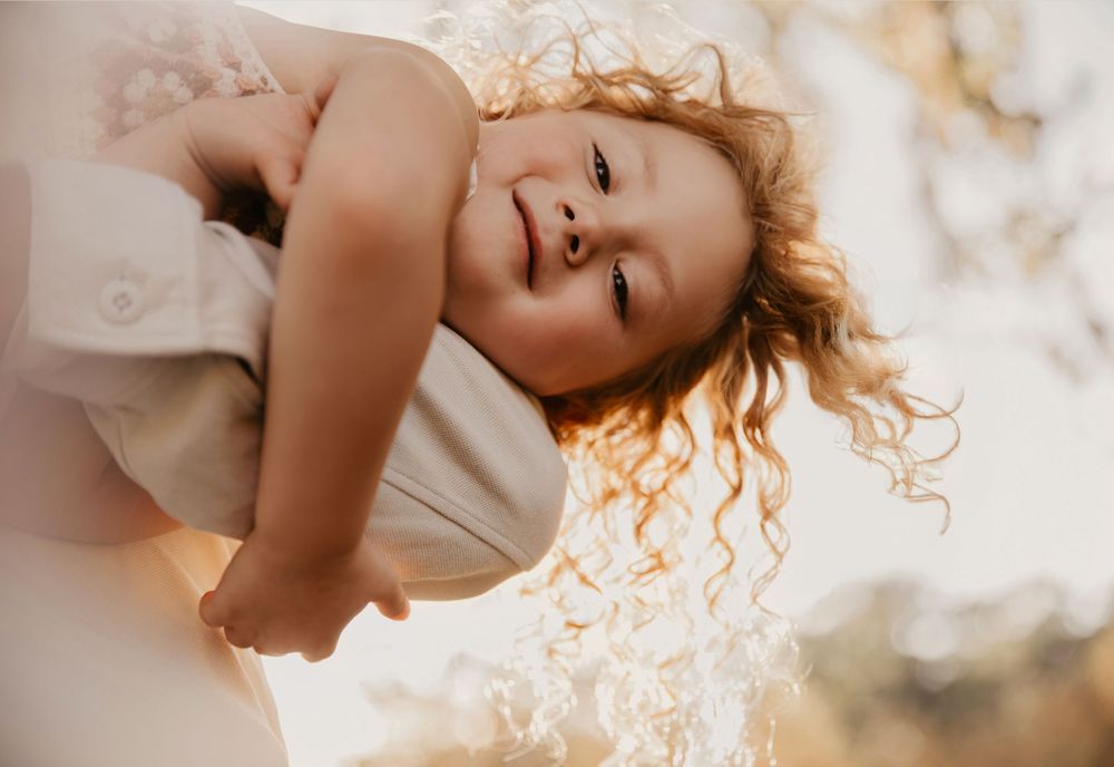 Intimate close-up portrait with soft natural lighting and flowing hair creating an ethereal mood.