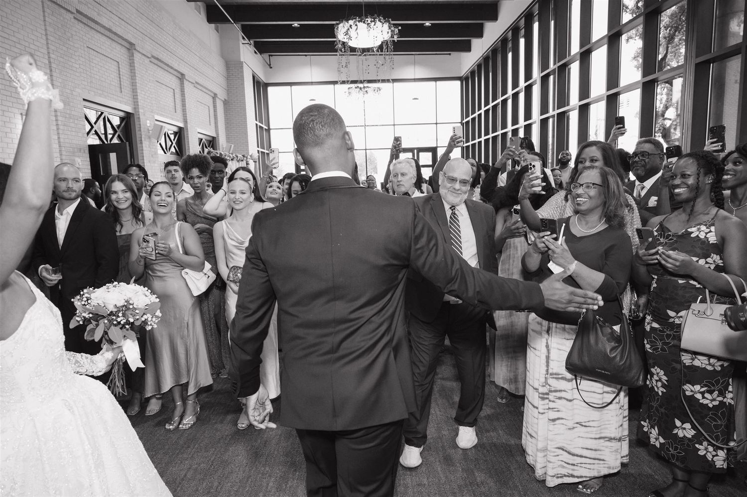 A wedding celebration in black and white showing guests socializing and mingling in an elegant indoor venue.