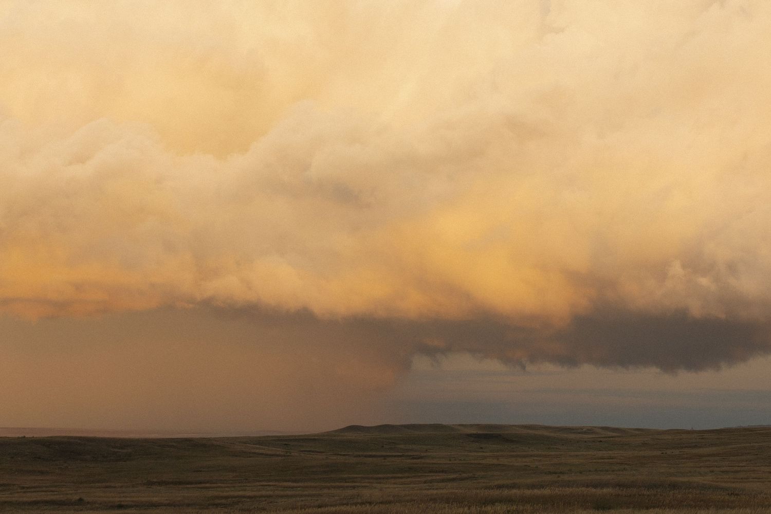 Dramatic orange sunset sky with dark clouds stretching across the horizon.