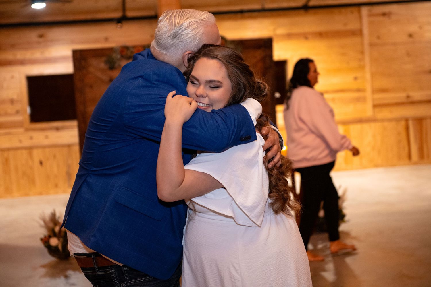 Emotional father- daughter hug during the wedding reception inside The Barn at Lakeside Ranch.