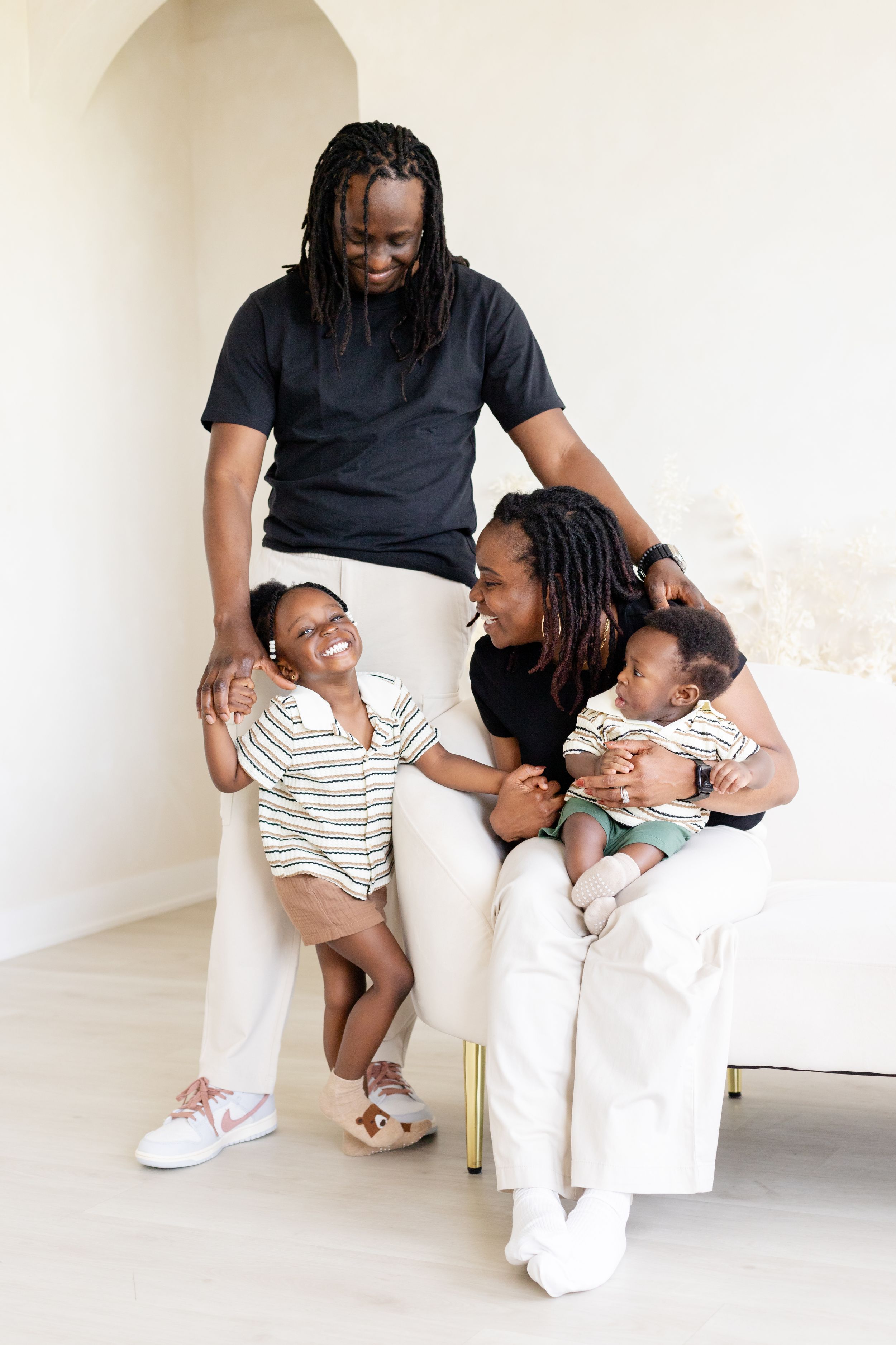 A series of four candid family portrait photos showing playful interaction in matching black and white outfits.