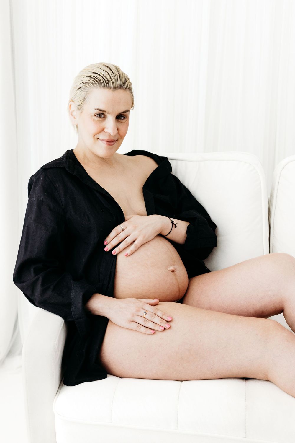 Mother cradling her growing baby bump.
