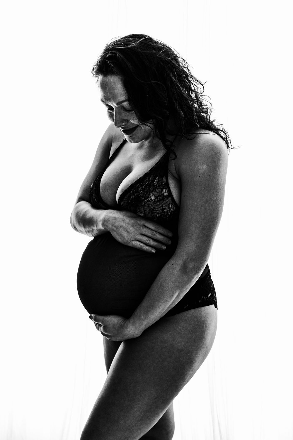 Minimal maternity photography with cream backdrop.
