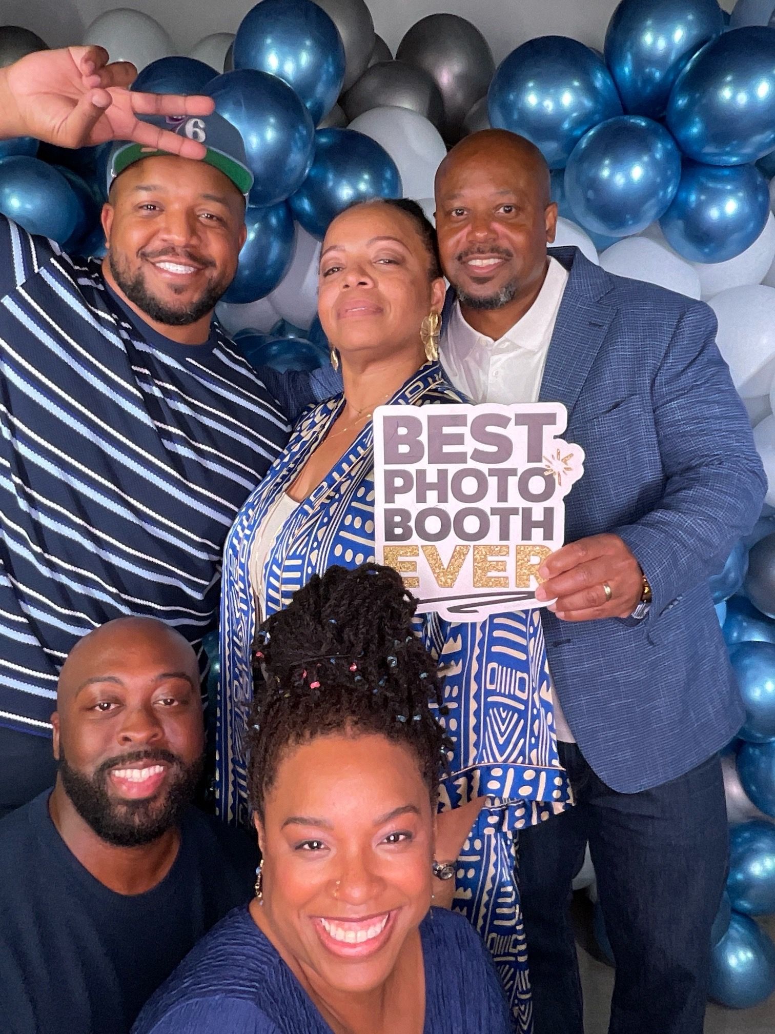 Group photo booth pictures showing people smiling and posing with blue balloon decorations in the background.