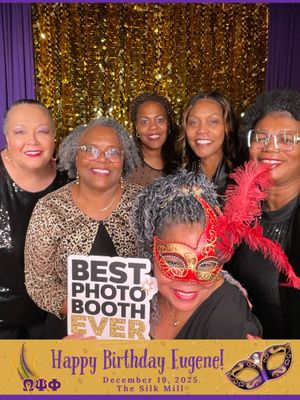 A group poses together at a photo booth with a gold sequin backdrop and purple birthday party decorations.