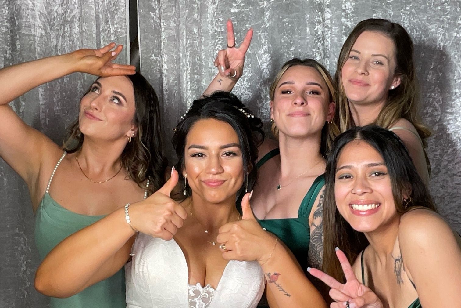 Group posing together in a photo booth with party accessories and props.