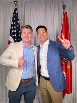 Four casual business photos show colleagues posing together in front of a grey curtain with American and red flags.