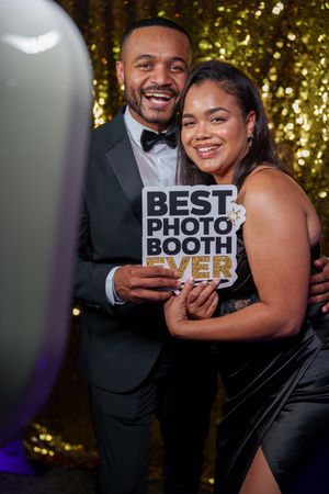 A festive photo booth sequence showing a couple displaying a "BEST PHOTO BOOTH EVER" sign against a golden backdrop.