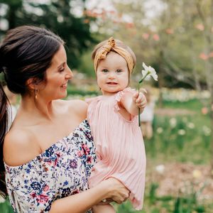 A tender moment captured in spring with soft pink and floral patterns.
