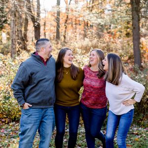 A group enjoying a candid moment together in an autumn forest setting.