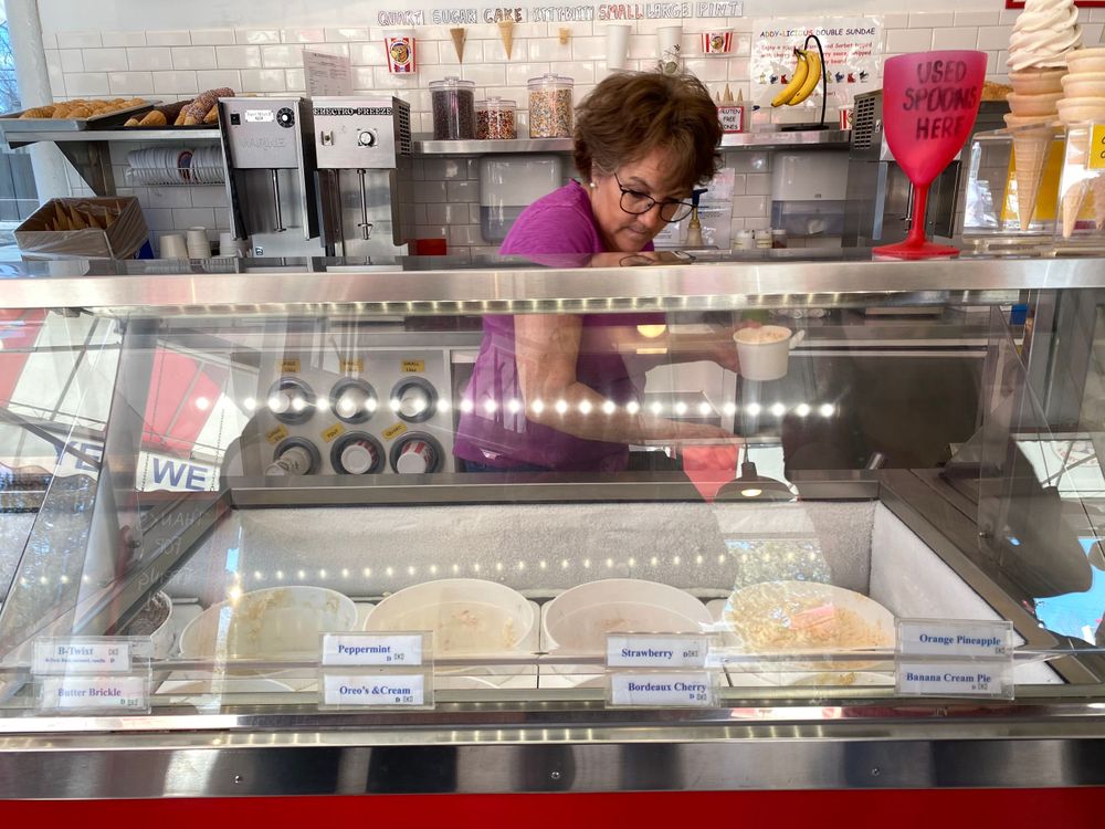 Food service counter with glass display case showing prepared items for sale.