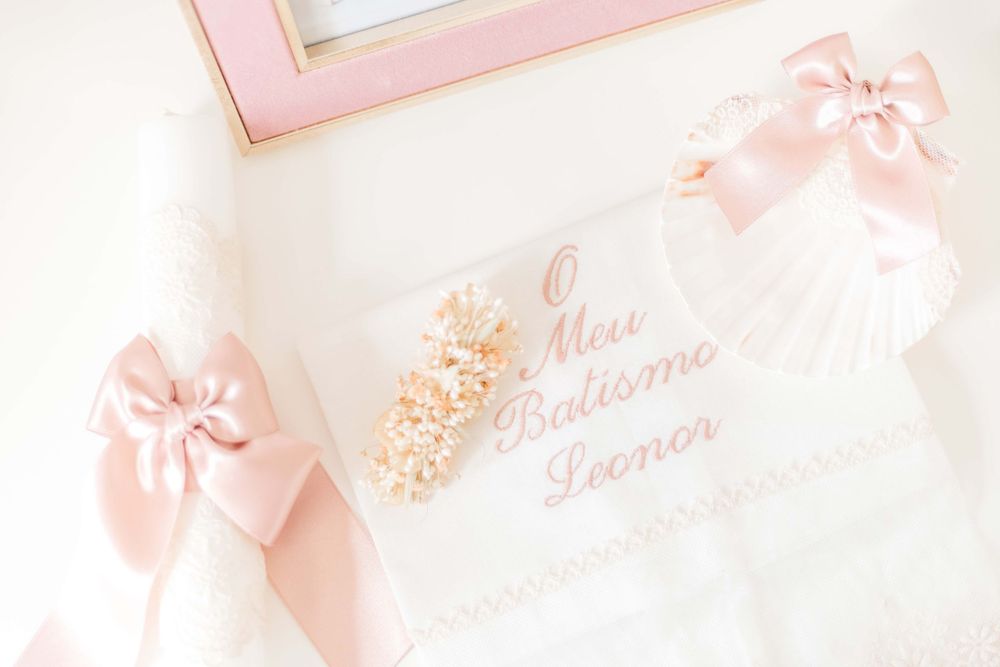 Elegant baptism invitation with pink bows and floral details on white background.