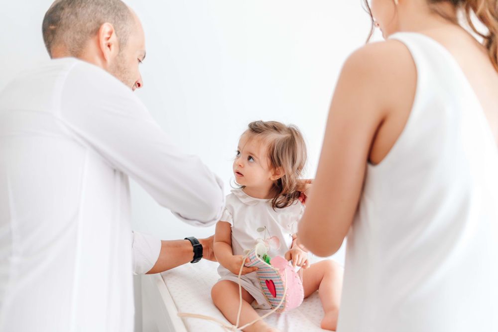 Family participating in a medical checkup with their toddler.
