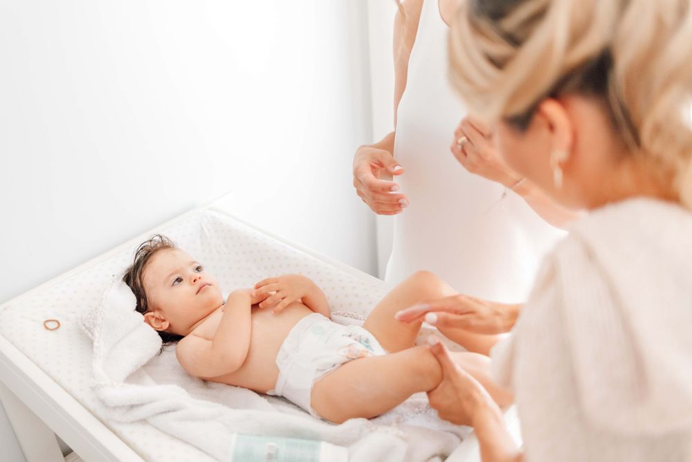 Baby lying on a changing table during a medical checkup.