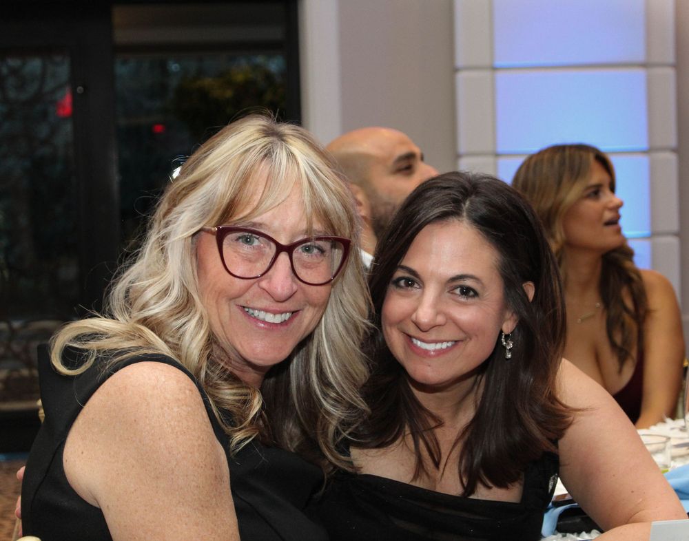Two attendees share a close moment at an evening celebration.