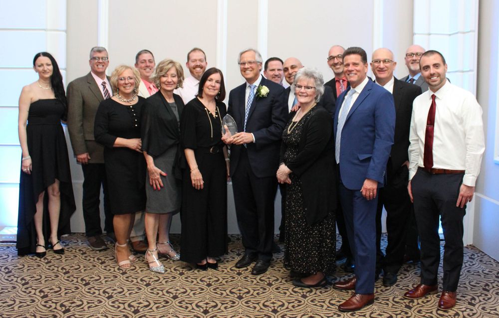 A large group photo of formally dressed guests at an awards ceremony or gala.