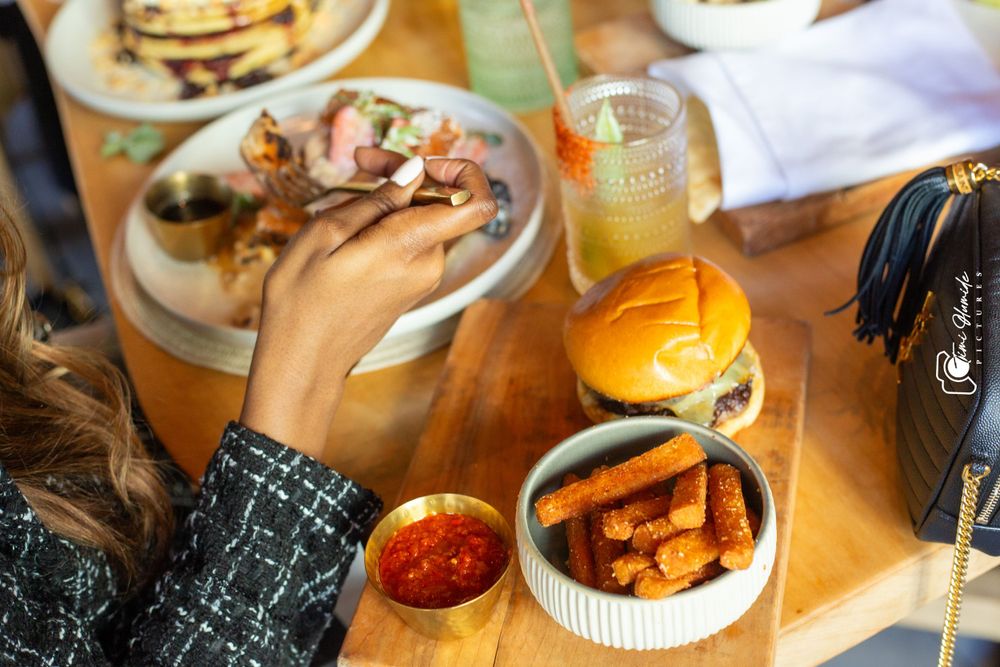 Table setting with burgers, fries, and drinks during a casual dining experience.