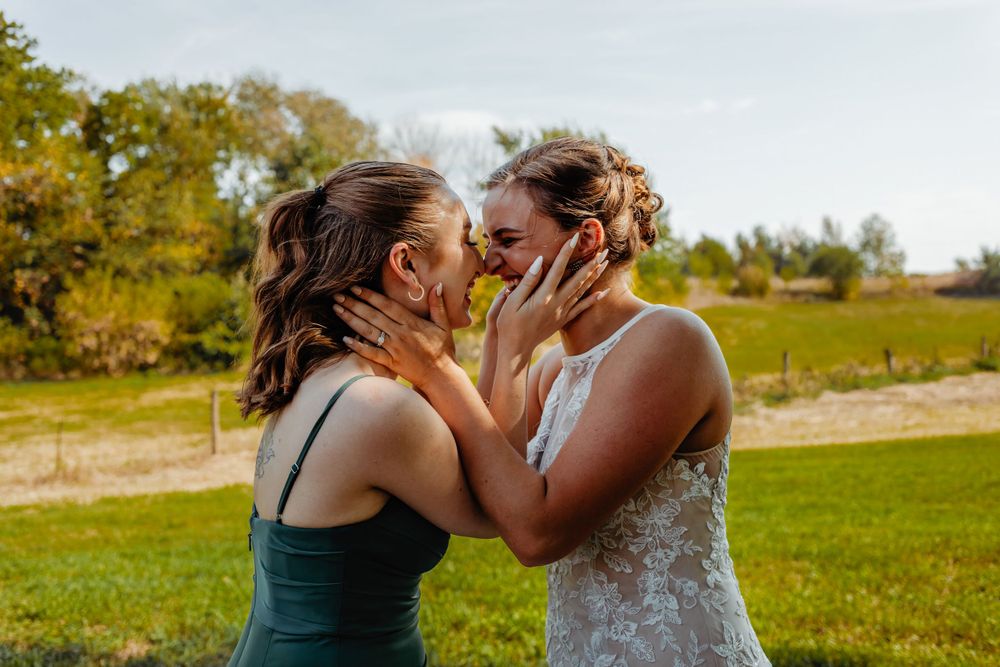 Two people sharing an emotional moment during a wedding celebration outdoors.