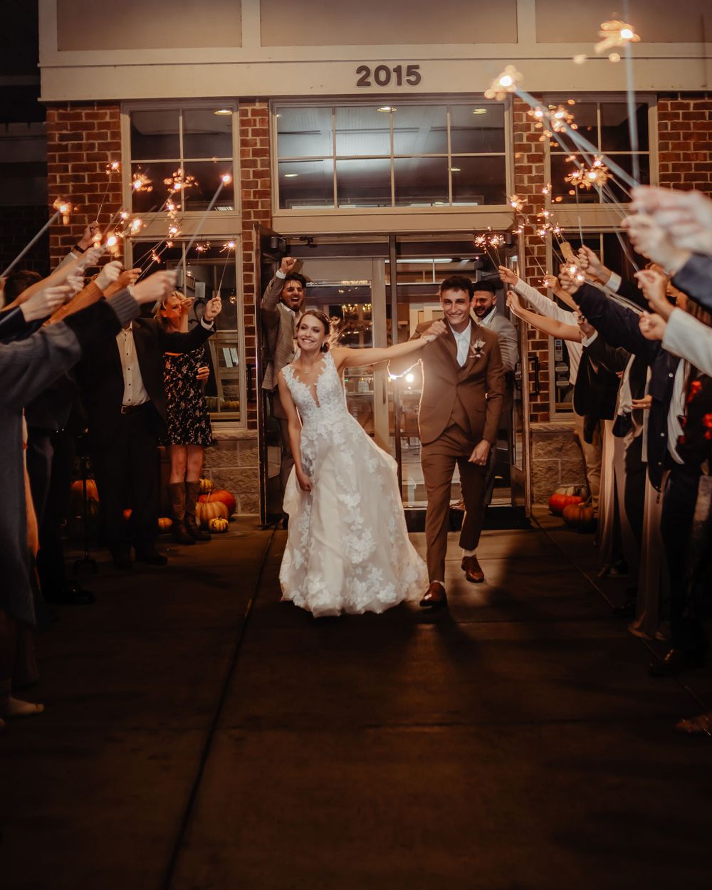 Newlyweds exit under a sparkler sendoff arch at their wedding reception.
