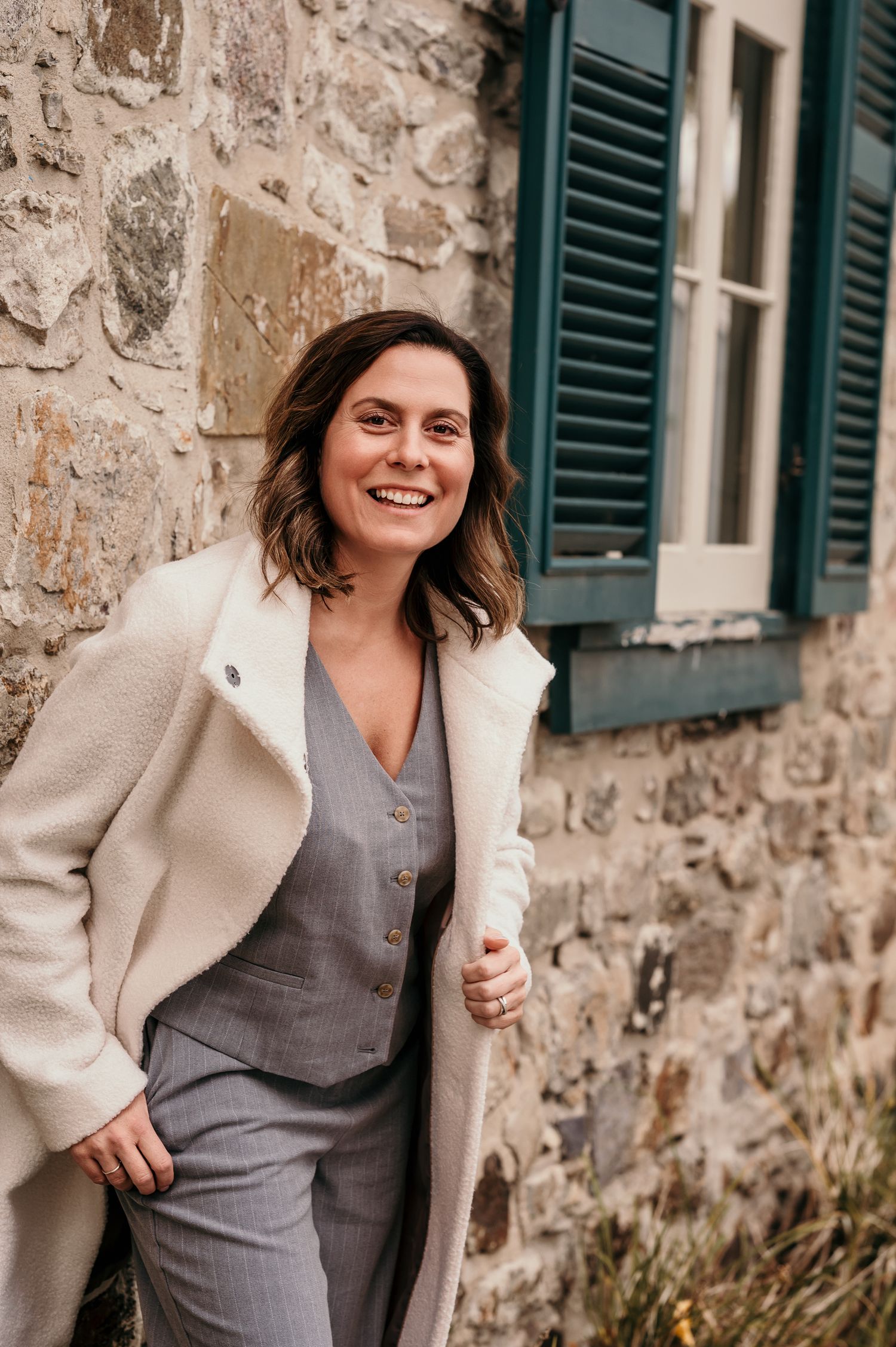 Casual portrait against a white wall with vintage architectural details.