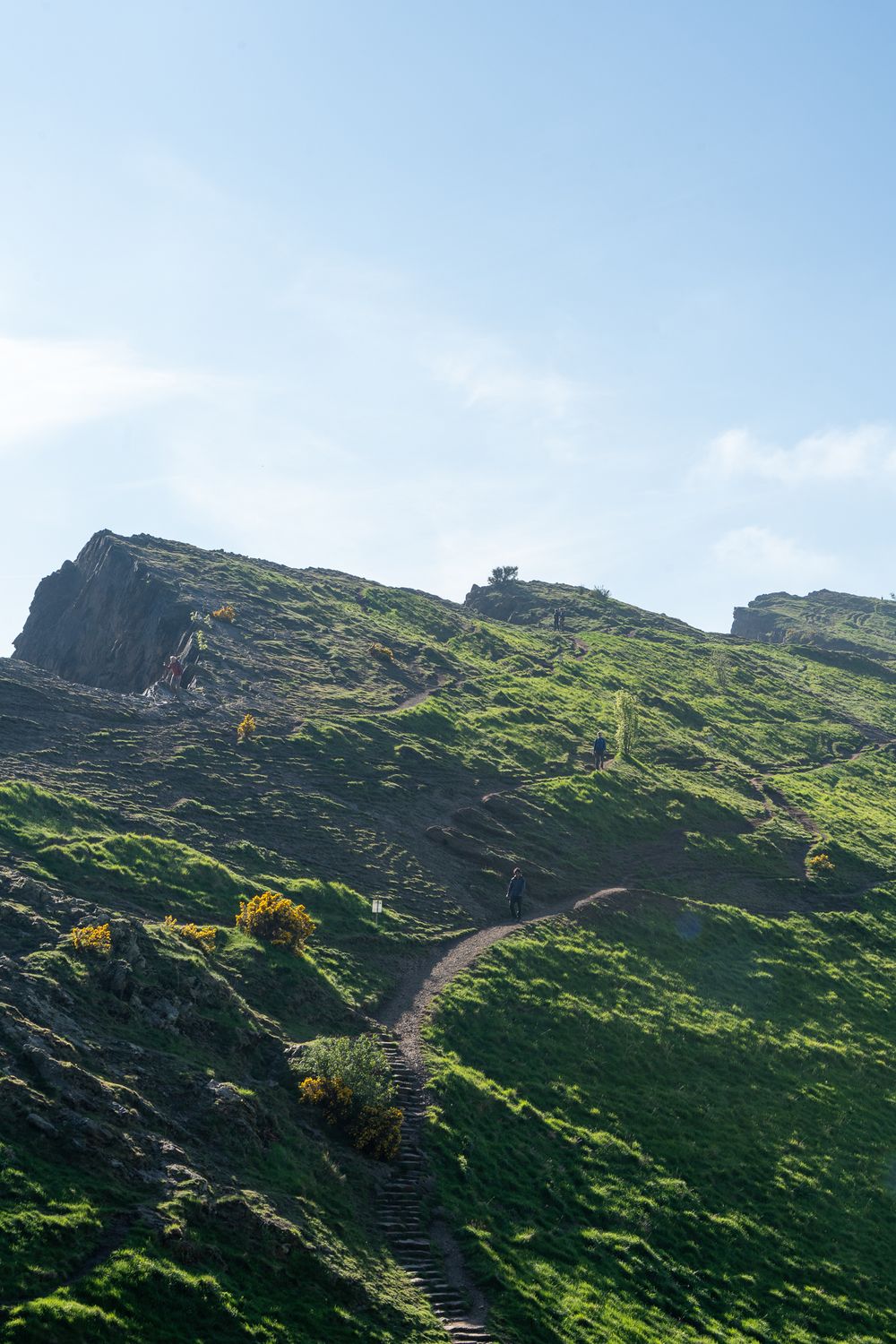 Steep grassy hillside with winding stone steps leading to the summit.