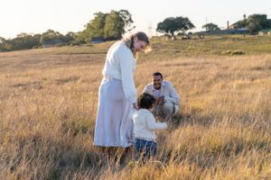Mother and toddler walk over to father at a family photo shoot in Rouse Hill Regional Park, Sydney.